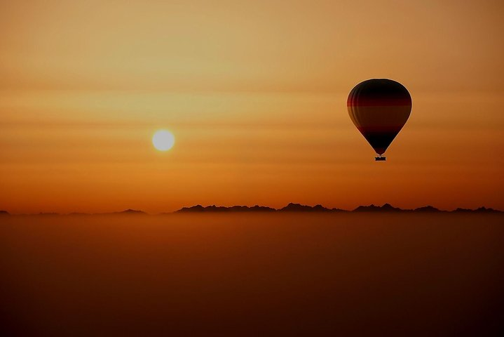 Witness the sun rising over the Arabian Desert as you float in a hot air balloon capturing the serene beauty and expansive landscapes of Dubai's breathtaking wilderness.